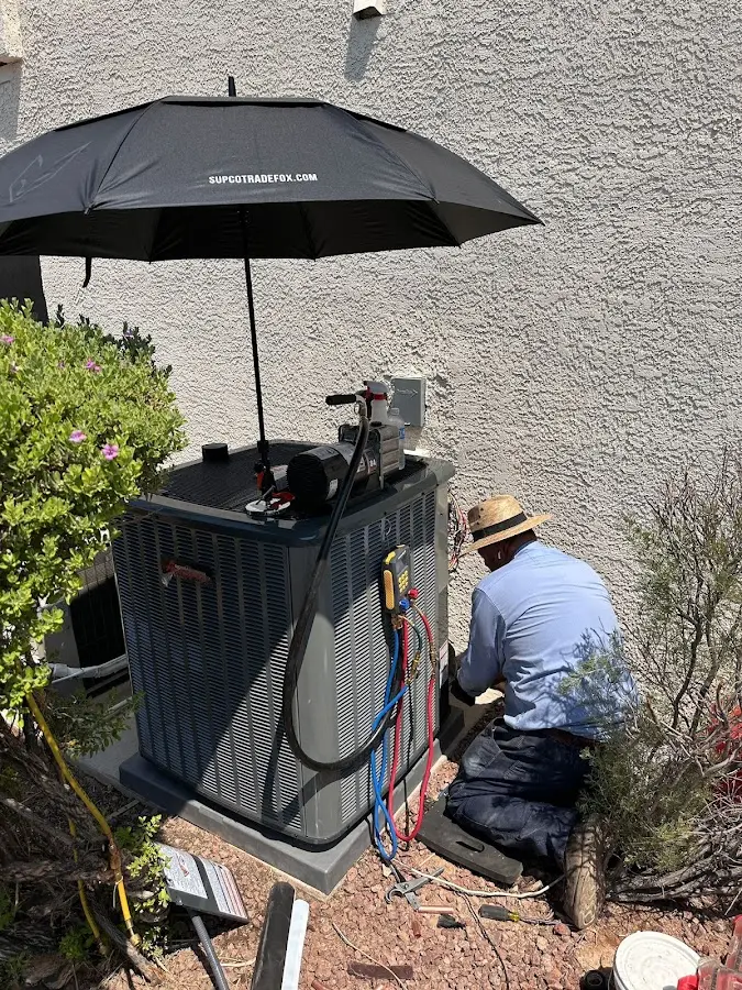 HVAC technician performing outdoor AC maintenance in Aston